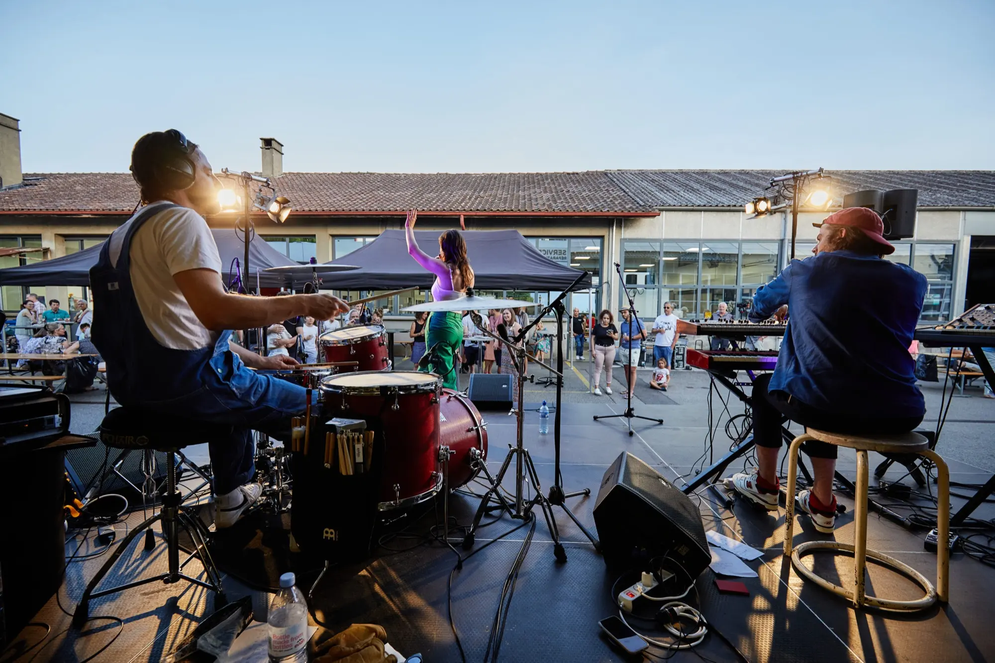 Des musiciens sur scène en plein air, devant le public, pendant les 100 ans du Garage Grin.